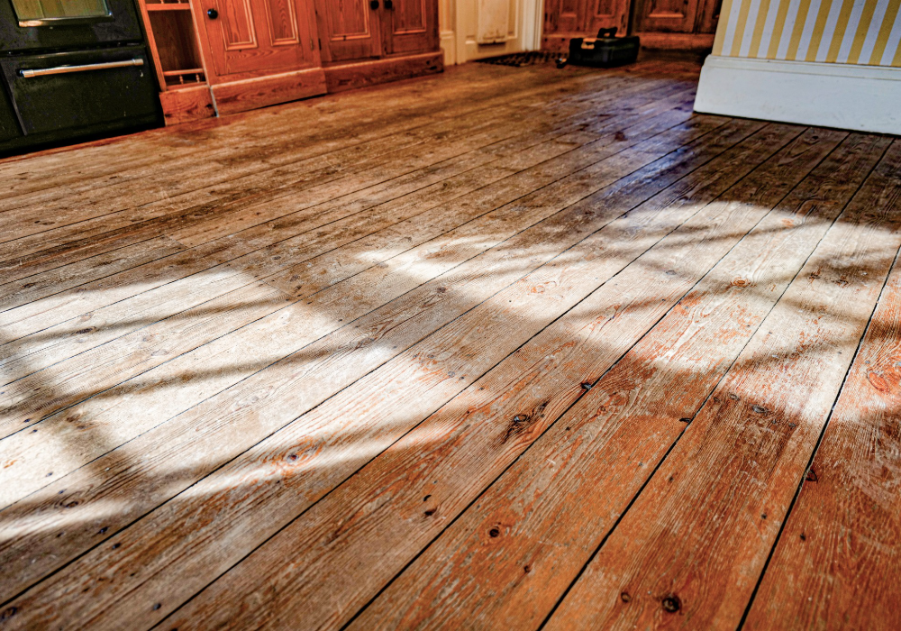 Faded and scratched pine flooring in need of expert care